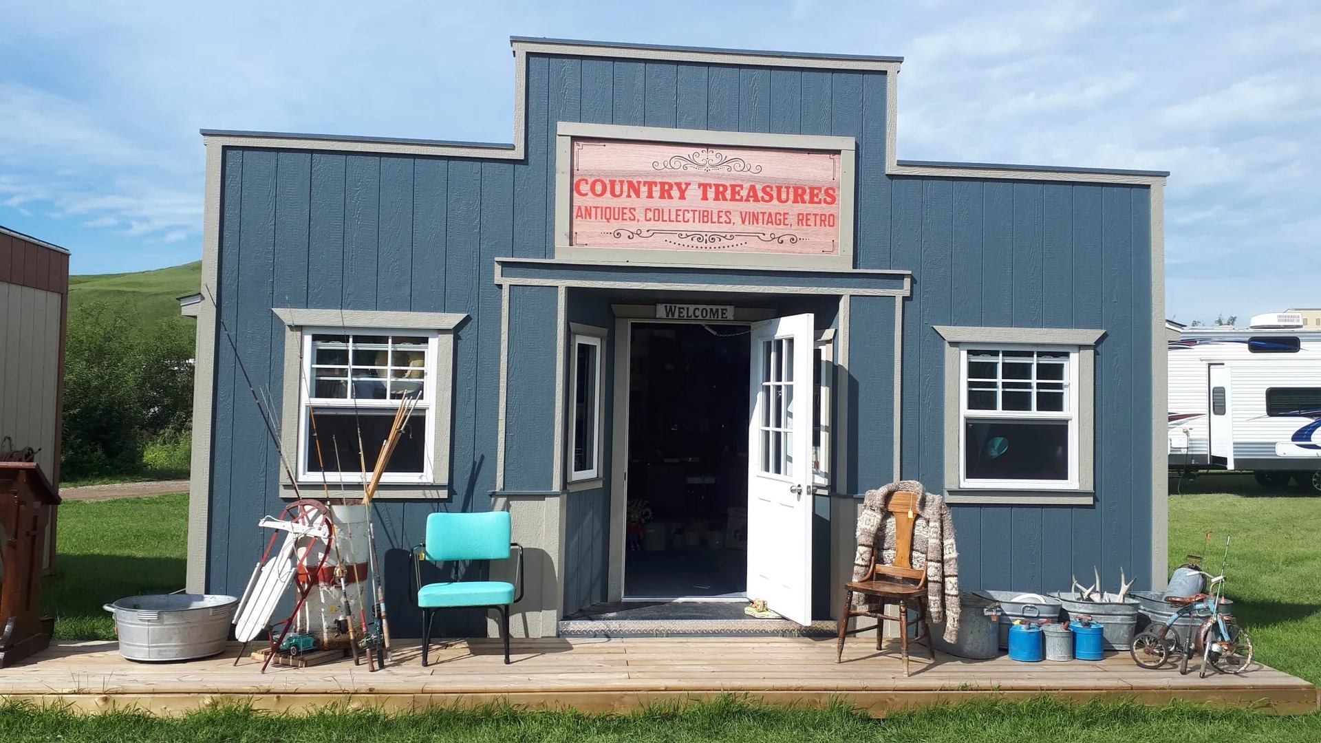 Blue shop with vintage items and open door labeled “Country Treasures.”