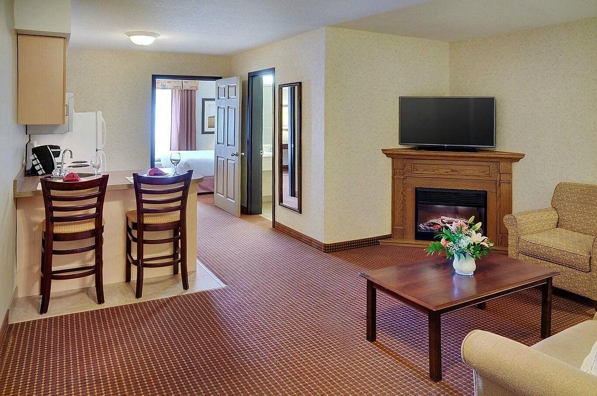 Spacious suite with seating area, fireplace, TV, and breakfast bar.