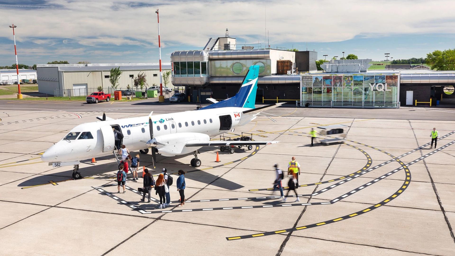 Small plane with passengers and staff on tarmac at Lethbridge County Airport.