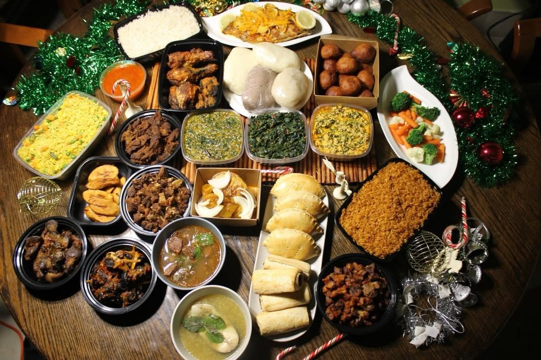 A large spread of West African dishes includes rice, soups, stews, meats, vegetables, and traditional sides.