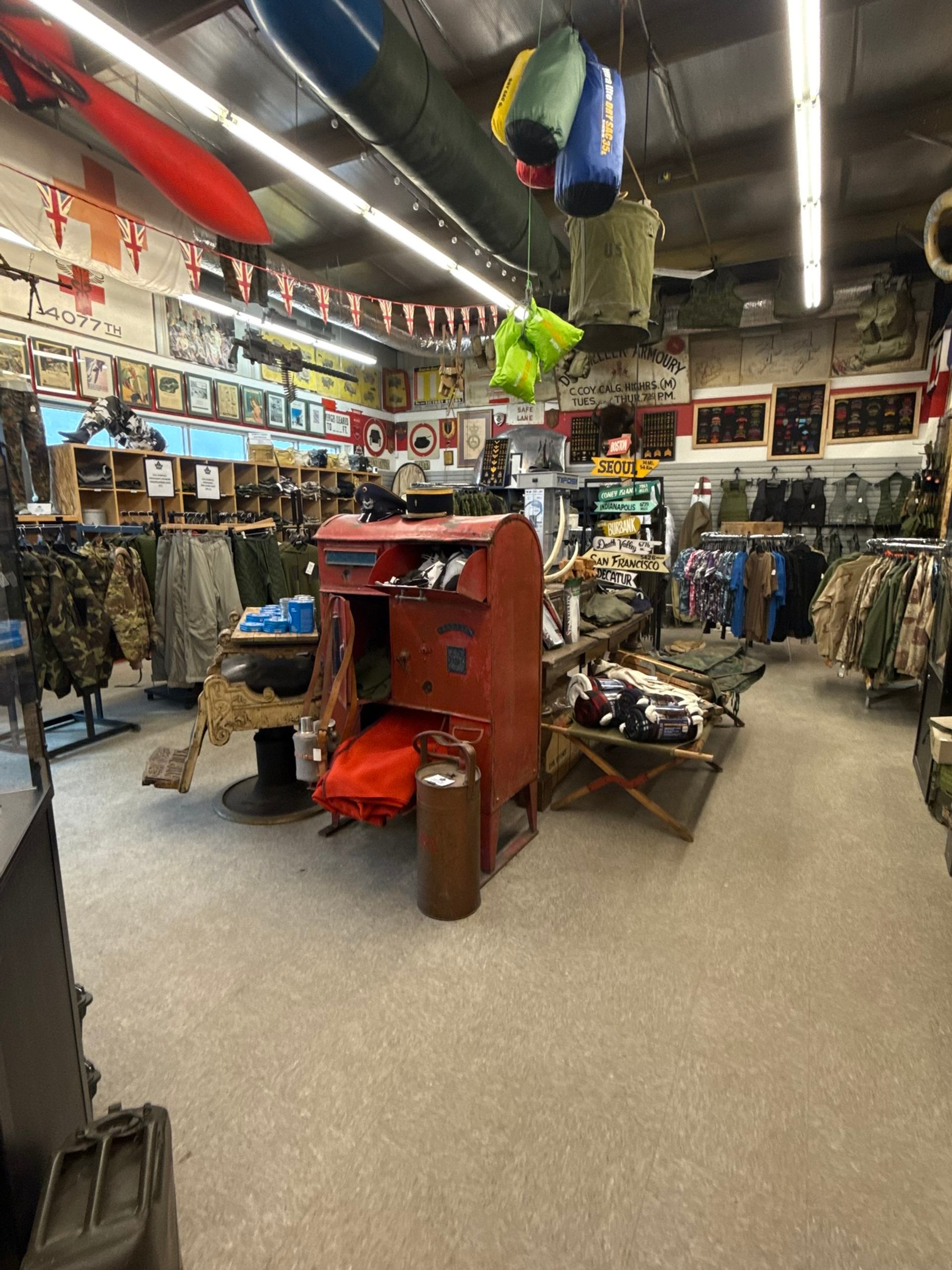 Crown Surplus Store interior shows military clothing, gear, and vintage items with flags, signage, and display cases.