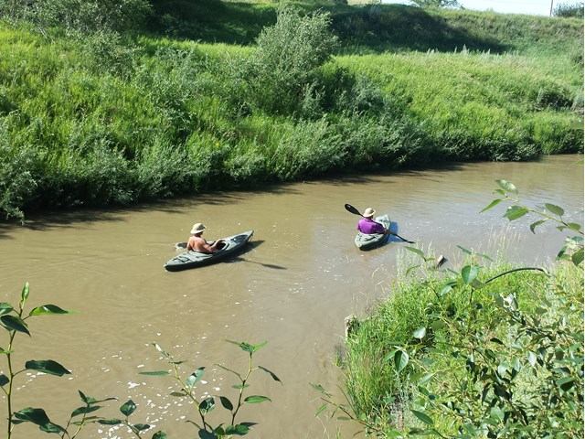 Two people in kayaks on the river.