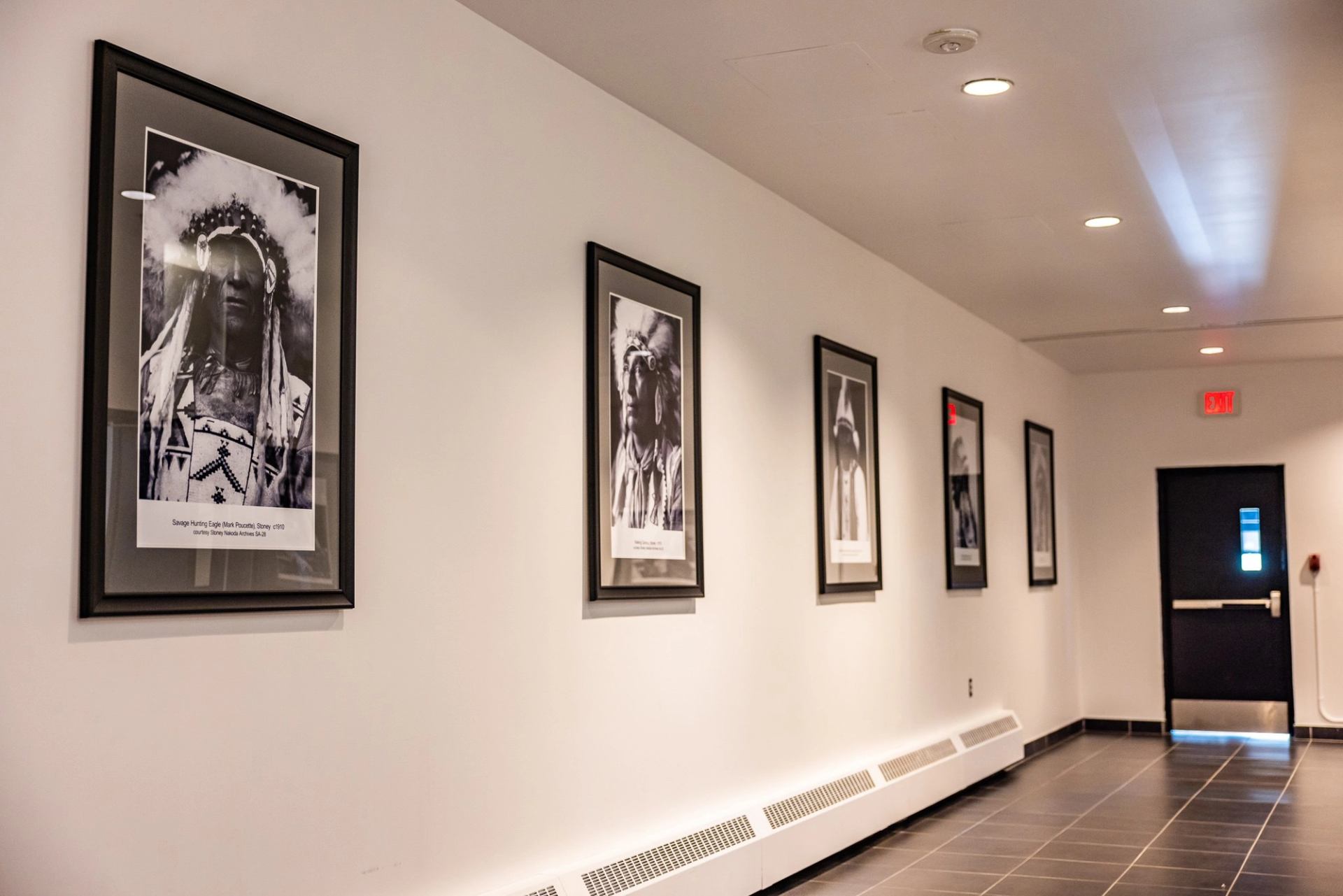 Tiled hallway with cultural photo display.