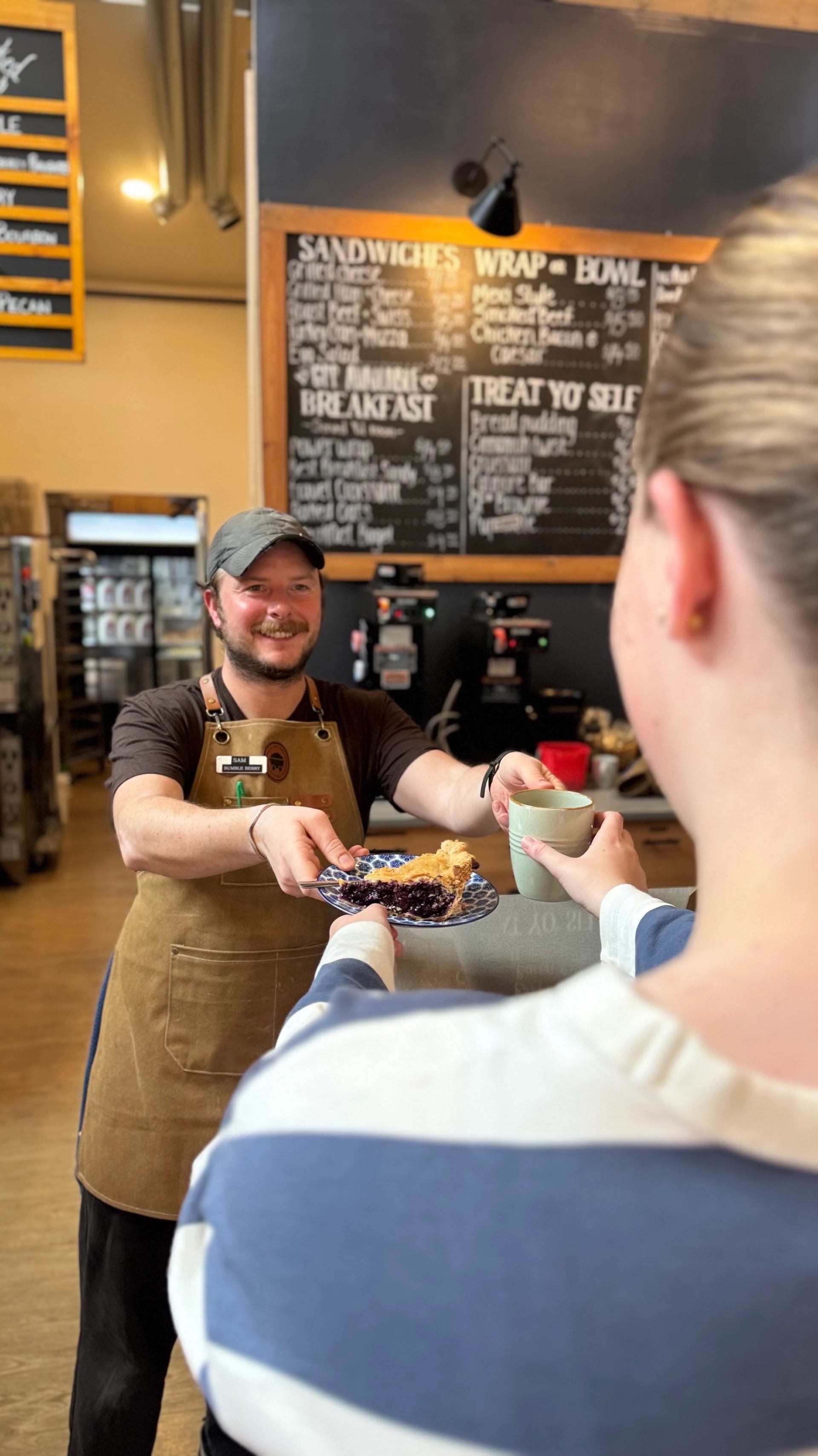 A café team member serves pie and coffee to a guest inside Miners' Café.