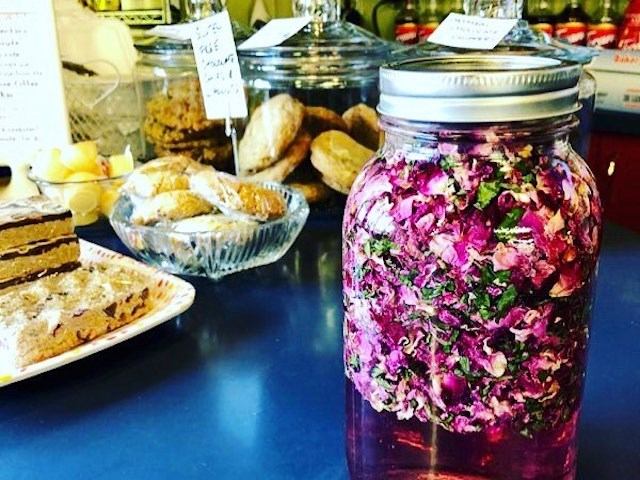 Glass jar filled with pink floral infusion on counter