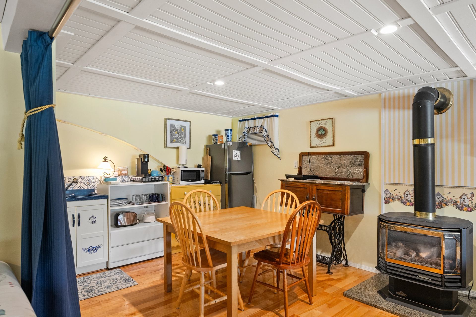 Warm kitchen nook with wooden table, stove, and vintage accents.