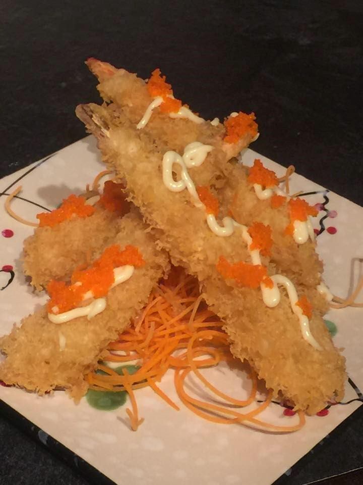 Golden fried shrimp tempura topped with sauce and roe on shredded garnish
