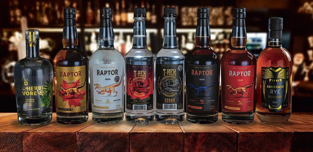 Assorted T‑Rex and Raptor spirits arranged on a wooden surface in a bar setting