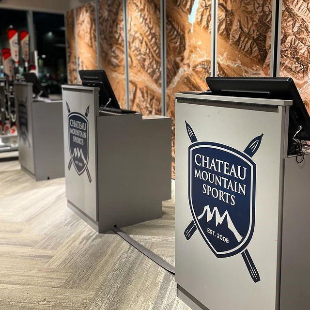 Chateau Mountain Sports checkout counters with ski-themed branding and map wall.
