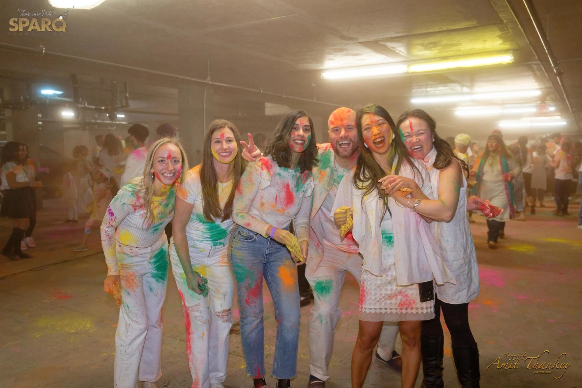Smiling people covered in colorful Holi powder.