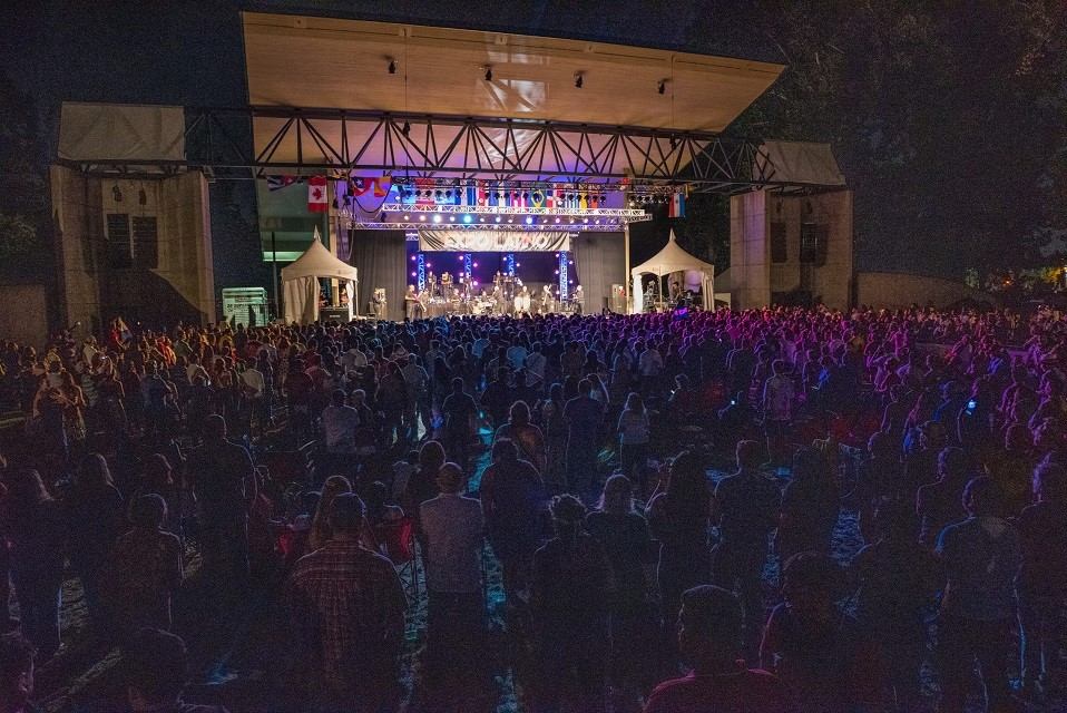 Expo Latino stage lit up with crowd and tents on sides.