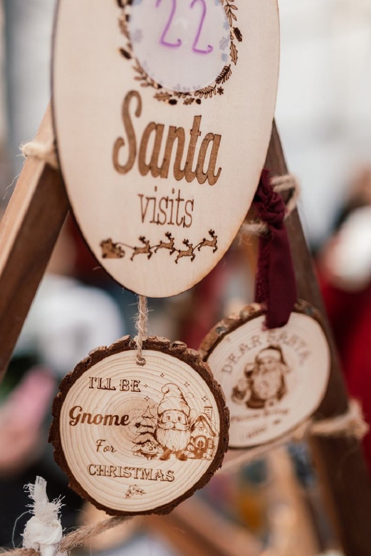 Wooden Christmas ornaments with festive engravings and illustrations on display.