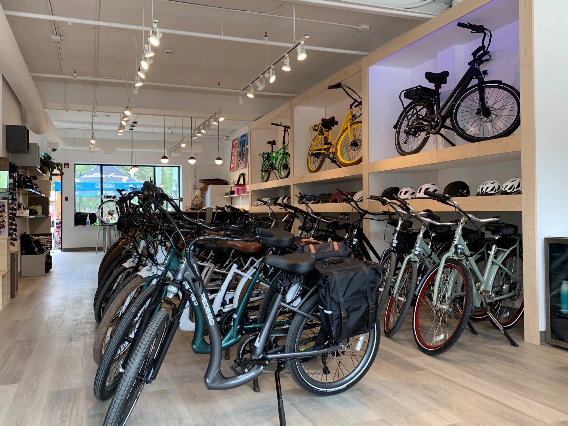 Interior of bike shop with rows of bikes and cycling gear on display.