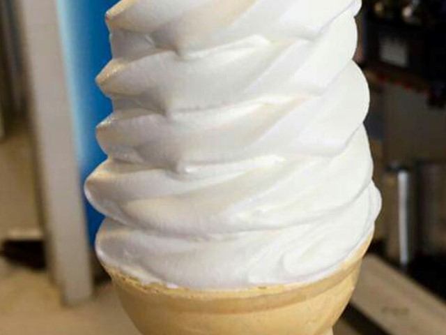 Close-up of a creamy vanilla soft-serve ice cream in a cone.