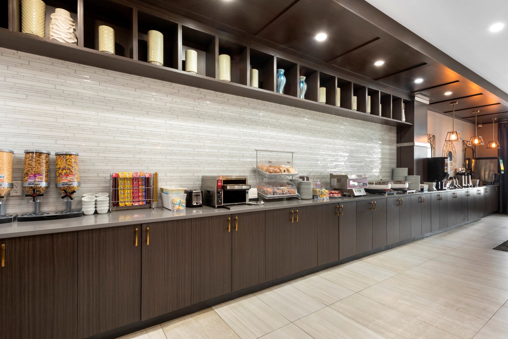 Hotel breakfast buffet with cereals, pastries, and coffee machines.