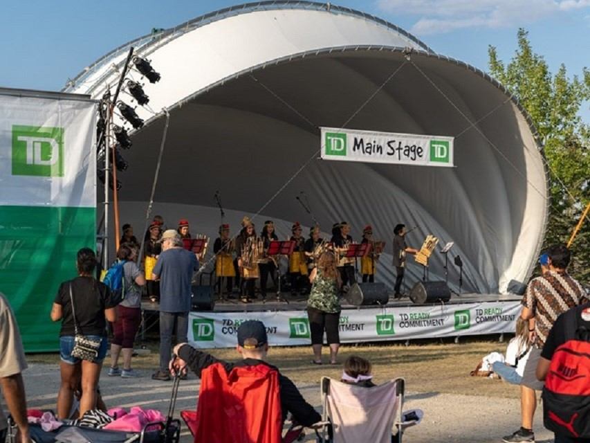 Live music stage with TD Main Stage signage and performers inside a large tent.