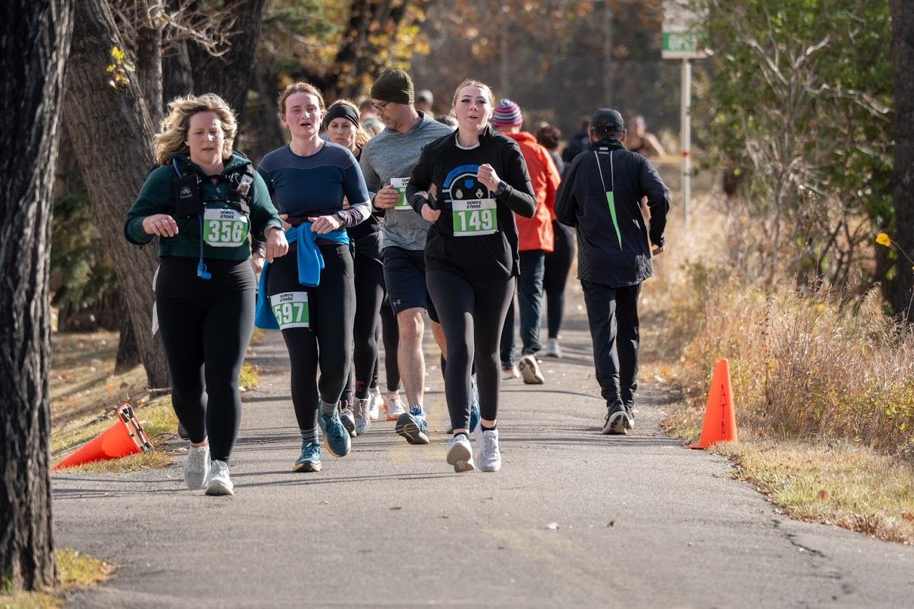 Runners on a paved trail passing orange cones during the First Responders Half Marathon.