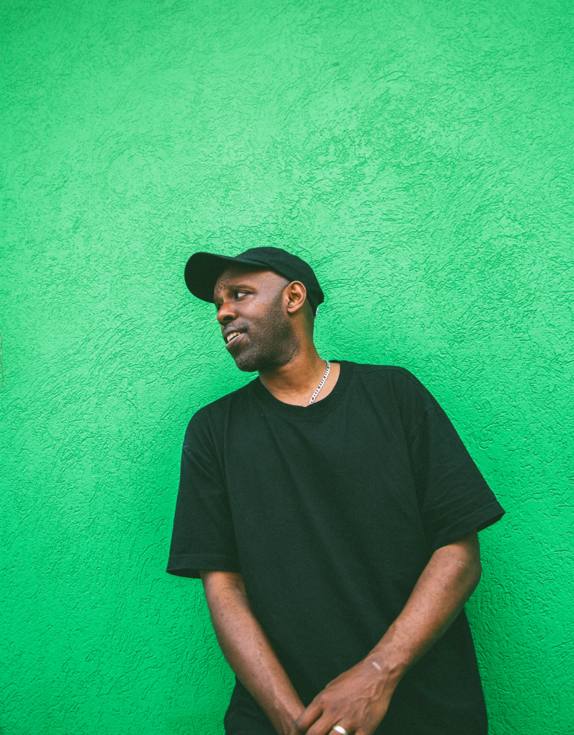 Shadrach Kabango standing against a green back drop