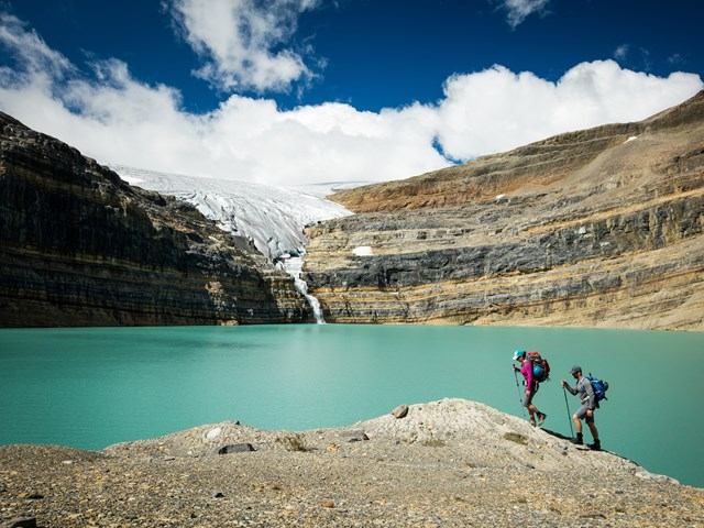 Two people hiking with Bow River in the background