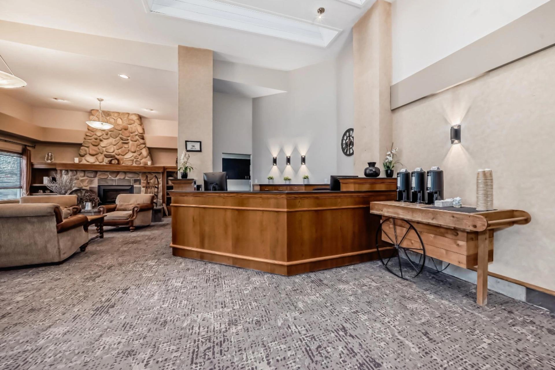 Hotel lobby featuring a wooden reception desk, coffee station, and stone fireplace