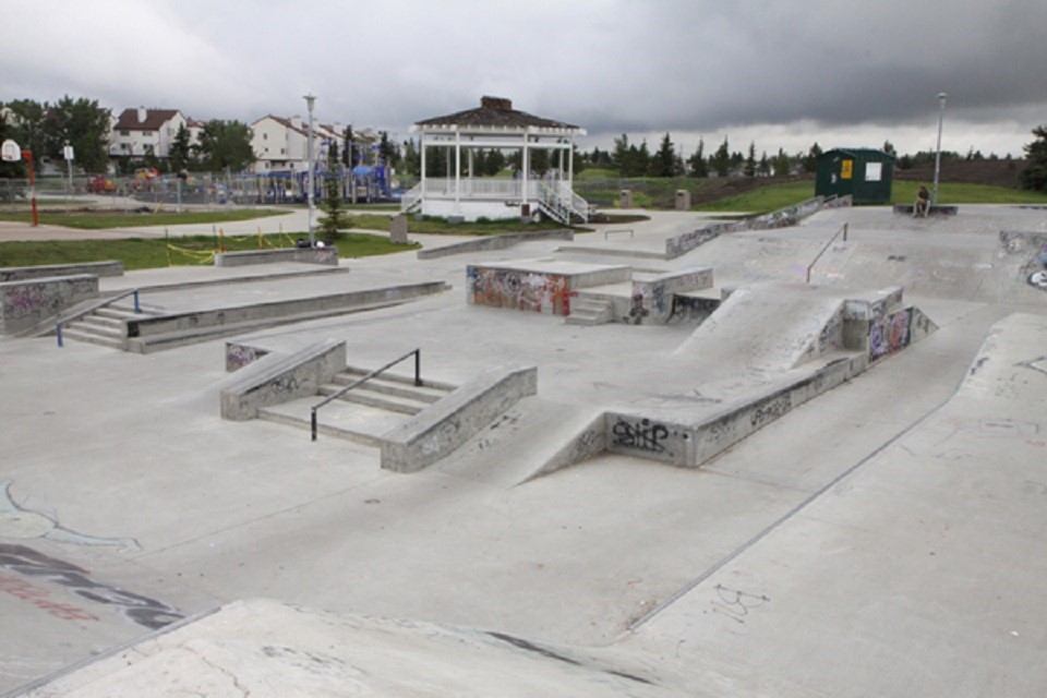 Skatepark with concrete bowls, ramps, metal rails, and a white gazebo in Edmonton.