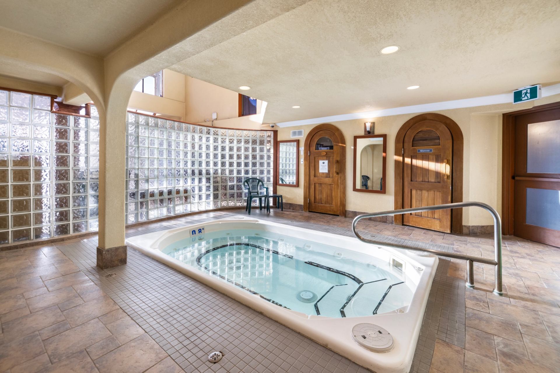 Indoor hot tub area with chairs, mirrors, and a relaxing spa atmosphere.