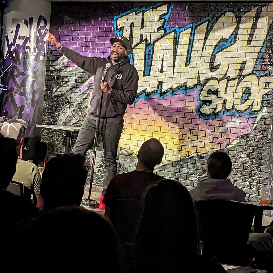Performer on stage at The Laugh Shop with crowd.