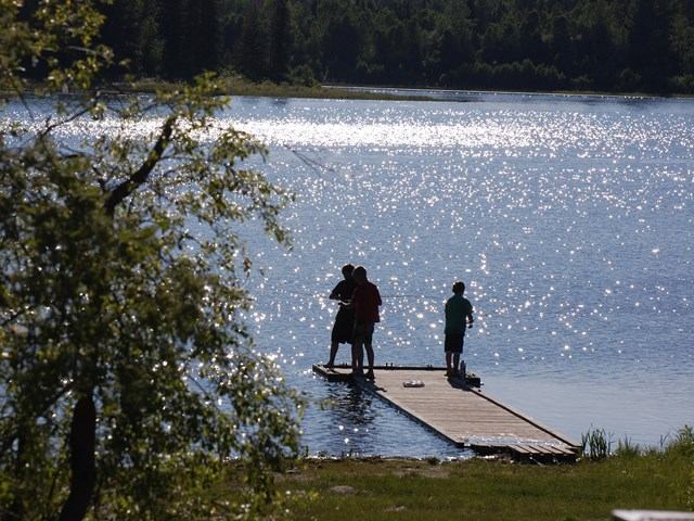 People standing on a dock in the water.