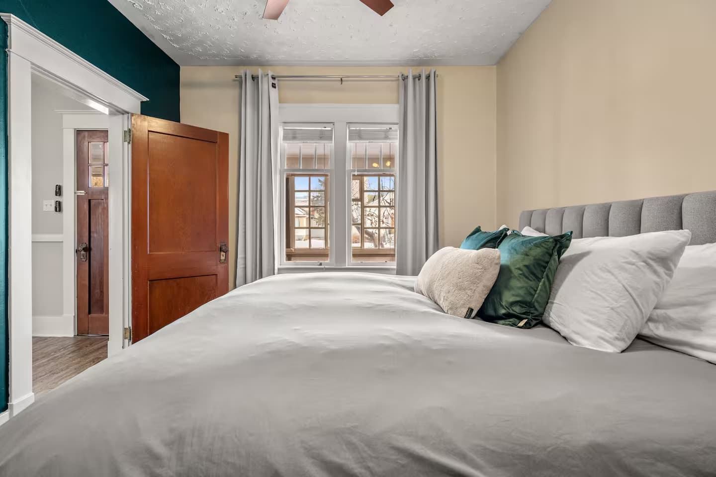 A master bedroom with windows leading to the patio