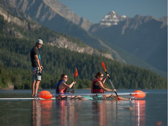 Kayakers and paddleboarders on a mountain lake.