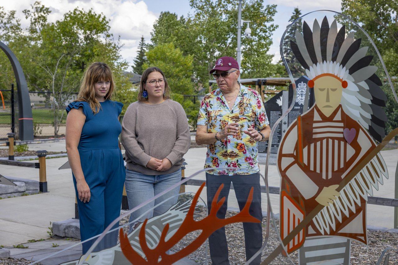 Invisible, a glass war memorial is being viewed by and elder and two female guests