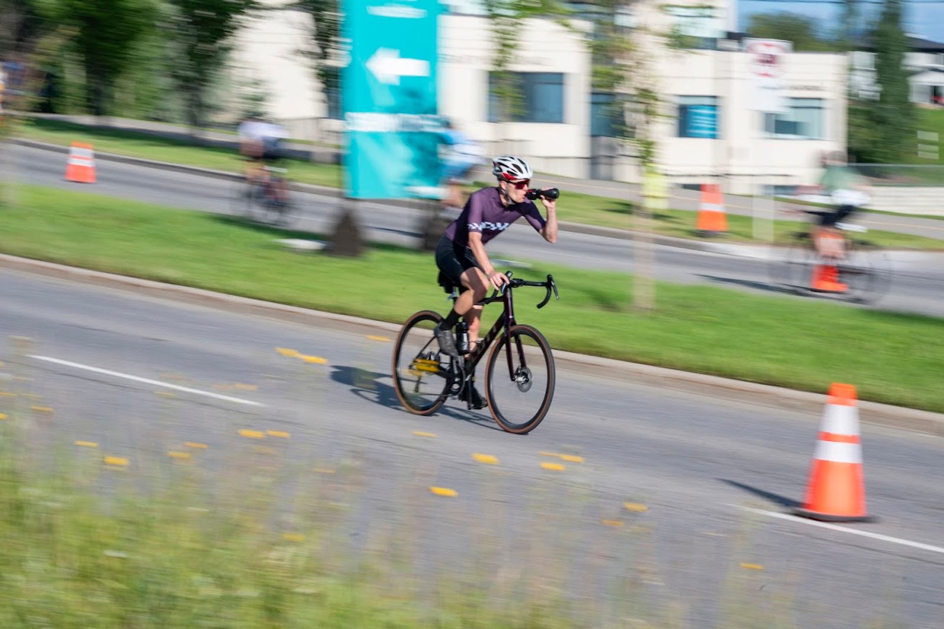 Cyclist racing on a paved road during the Lake Chaparral Triathlon with motion blur effect.