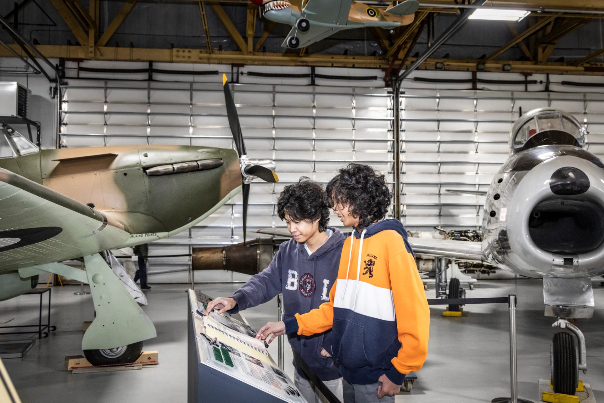 Two boys reading information at aviation museum exhibit