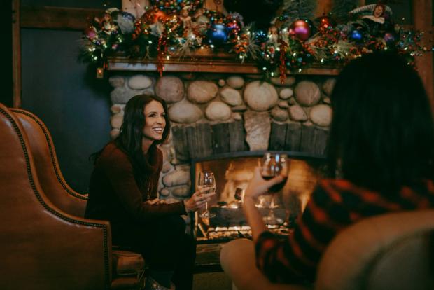 Two women having a drink by the fireplace at Buffalo Mountain Lodge