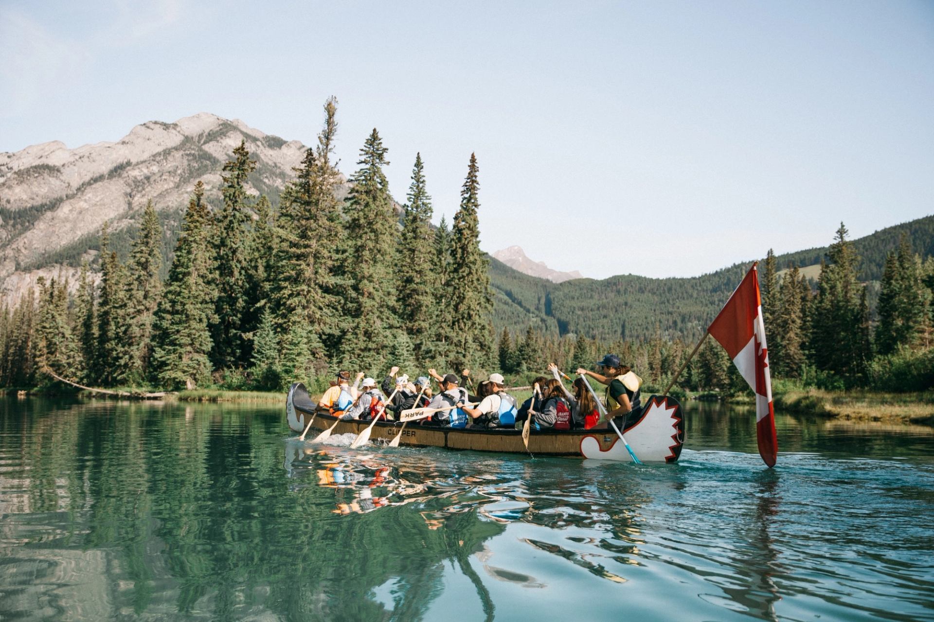 A group of people rowing in a big canoe