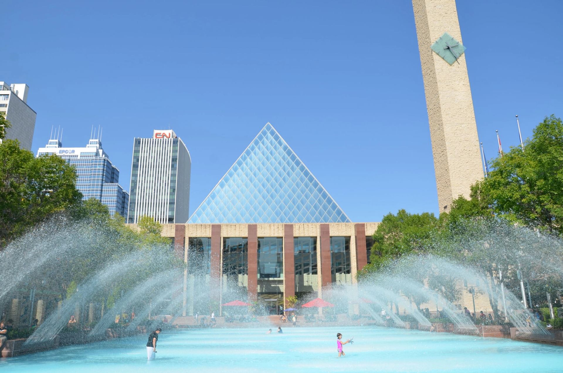Family splashing in the water fountain at Sir Winston Churchill Square in Edmonton