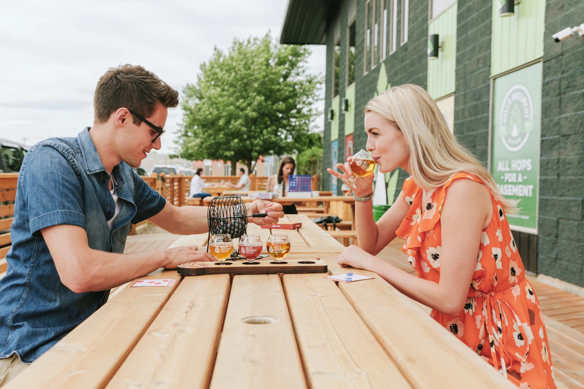 Two people sat outside on a brewery patio enjoying brews.
