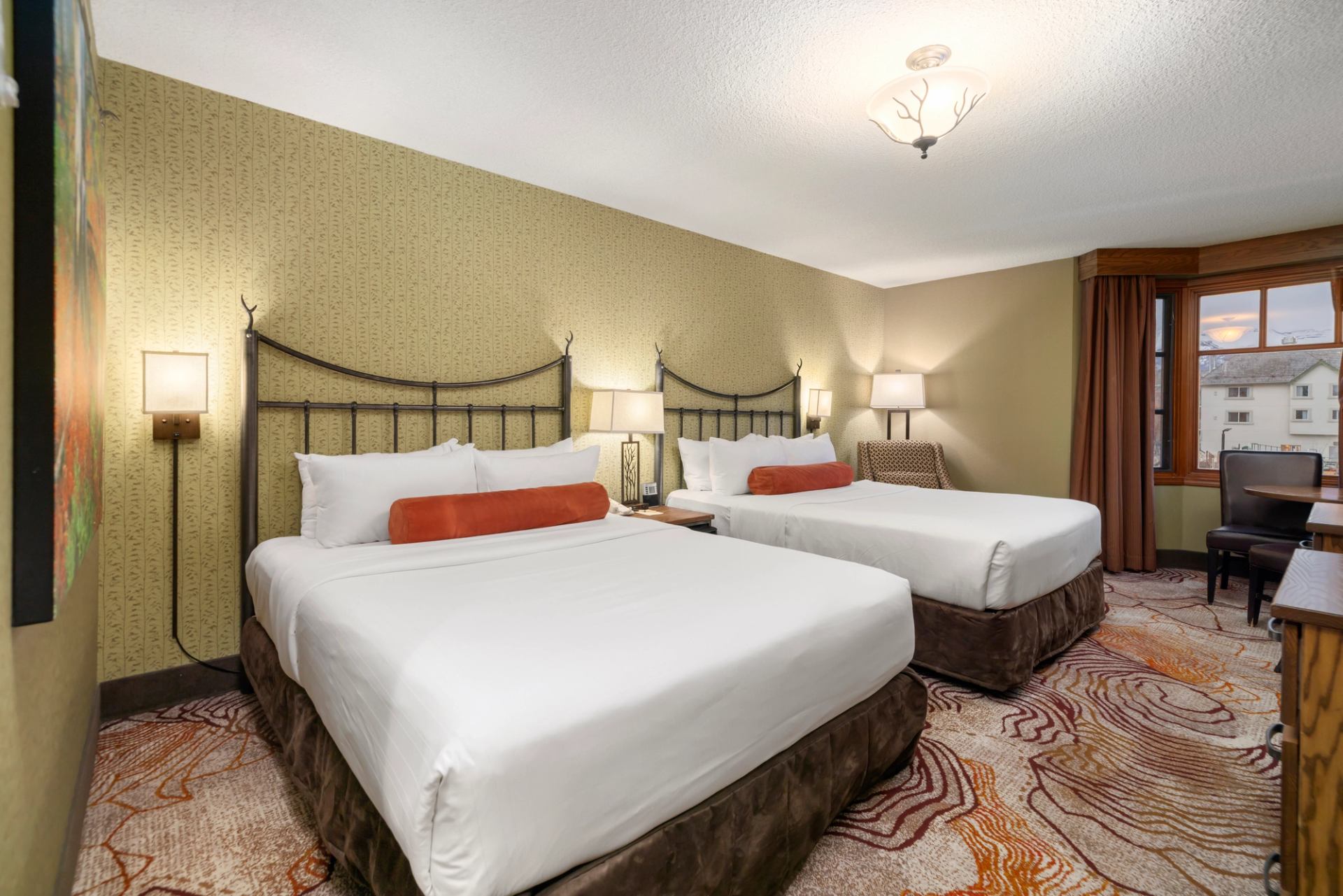 Hotel room with two queen beds with red pillows