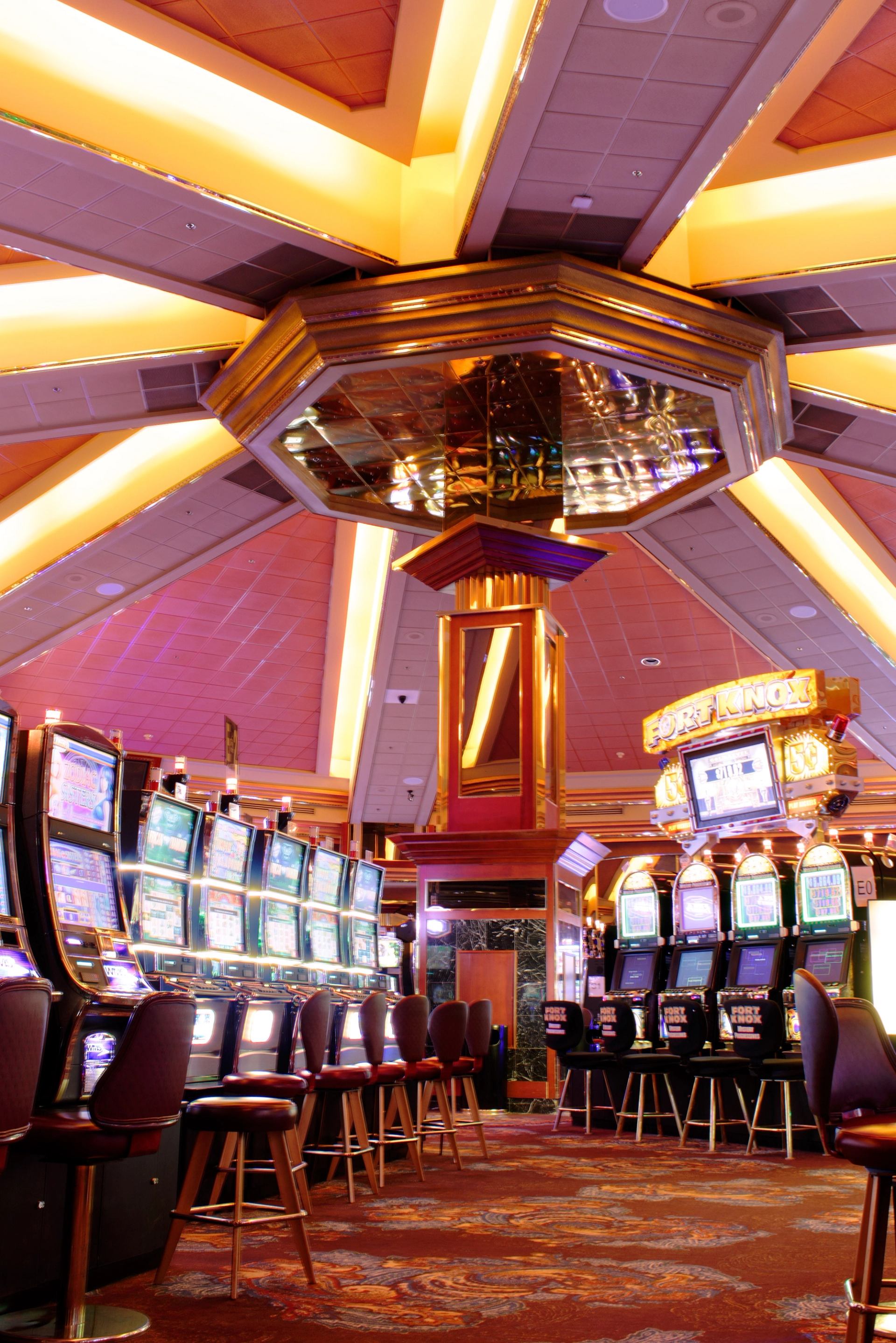 Casino floor with rows of slot machines, stools, and Fort Knox sign.
