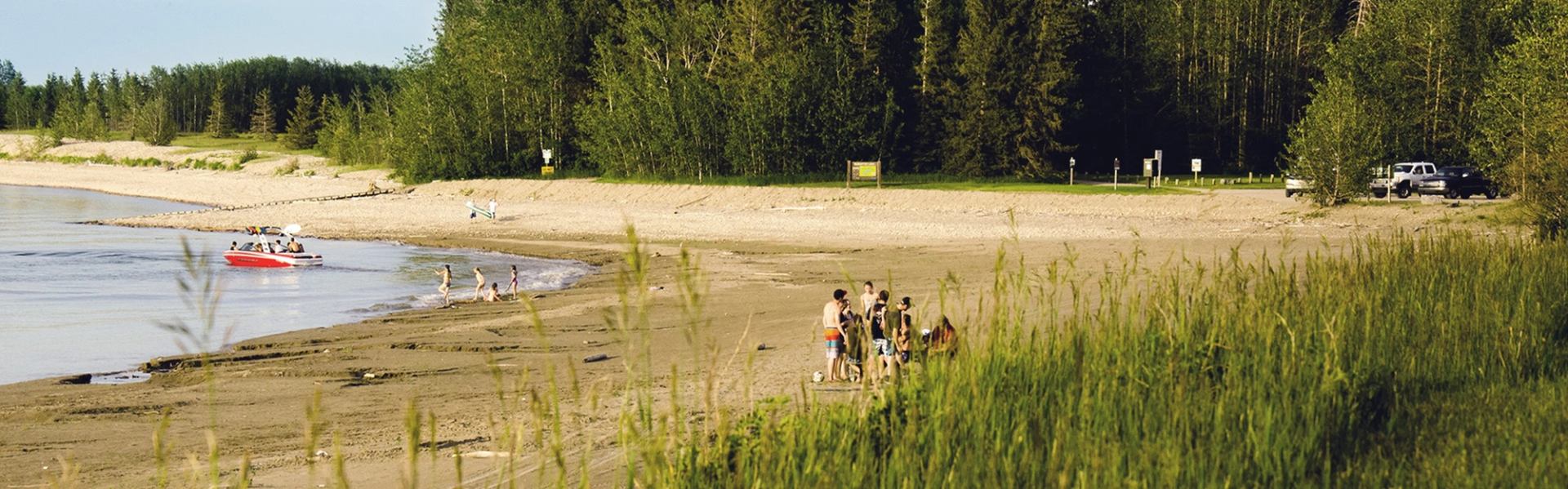 Open campsites by reservoir with boat launch and forest beyond