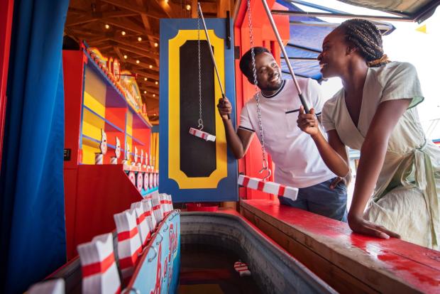 A couple try their hand at a game while enjoying Fort Edmonton Park.