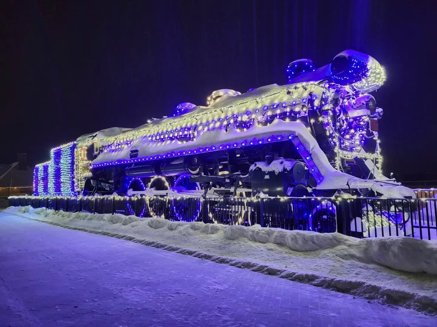 Snow-covered train decorated with blue and white lights at Jasper in January.