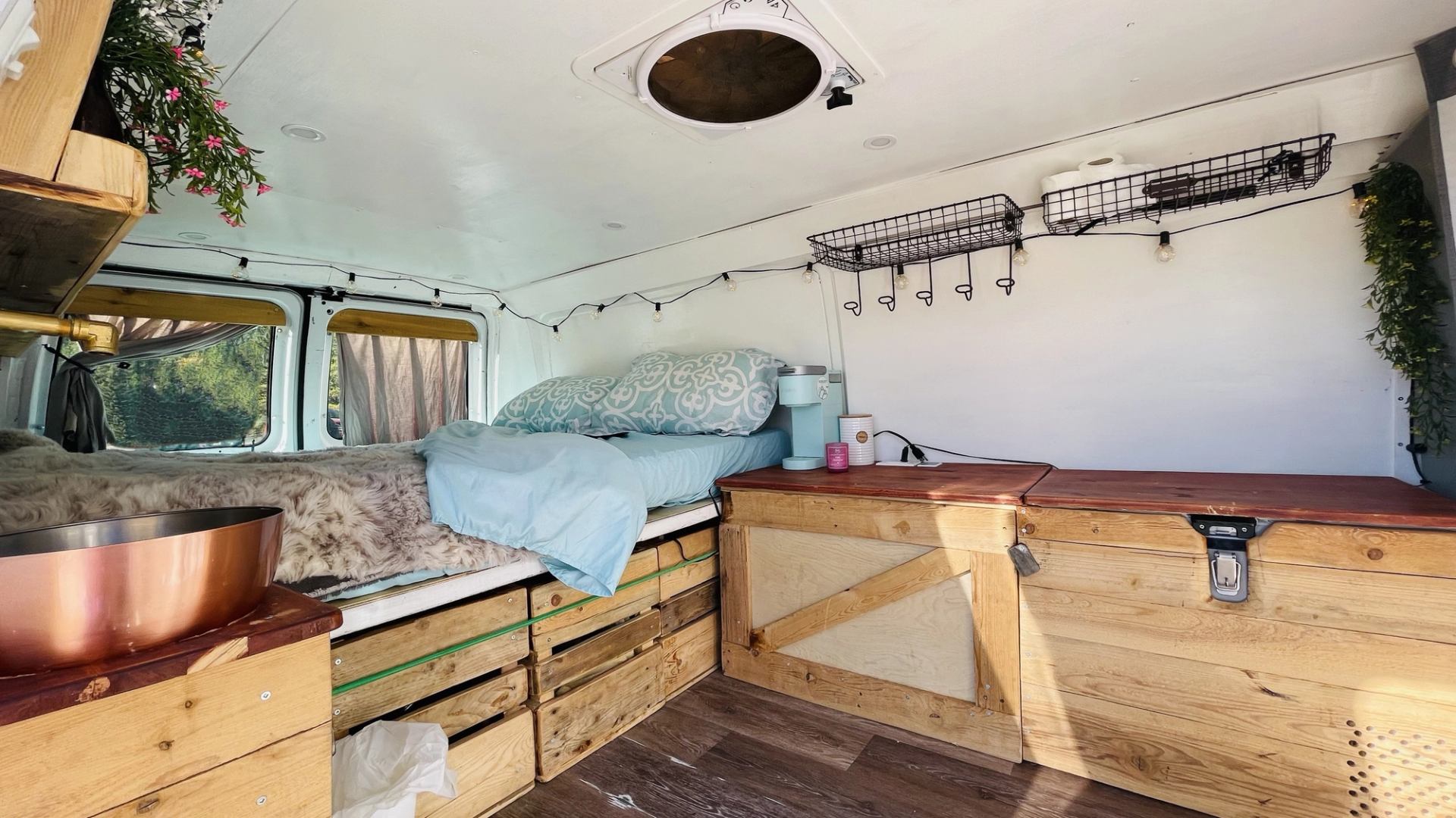 Van interior with bed, shelves, and cozy travel setup.