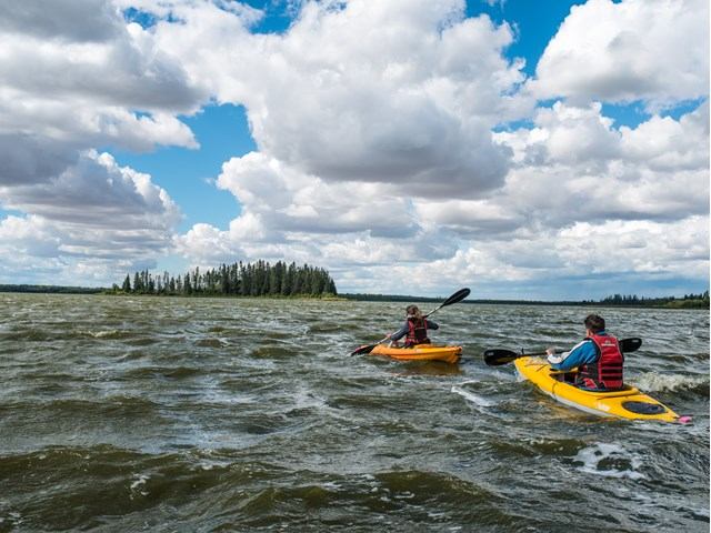 People kayaking on a lake near Sandy Beach Campground.