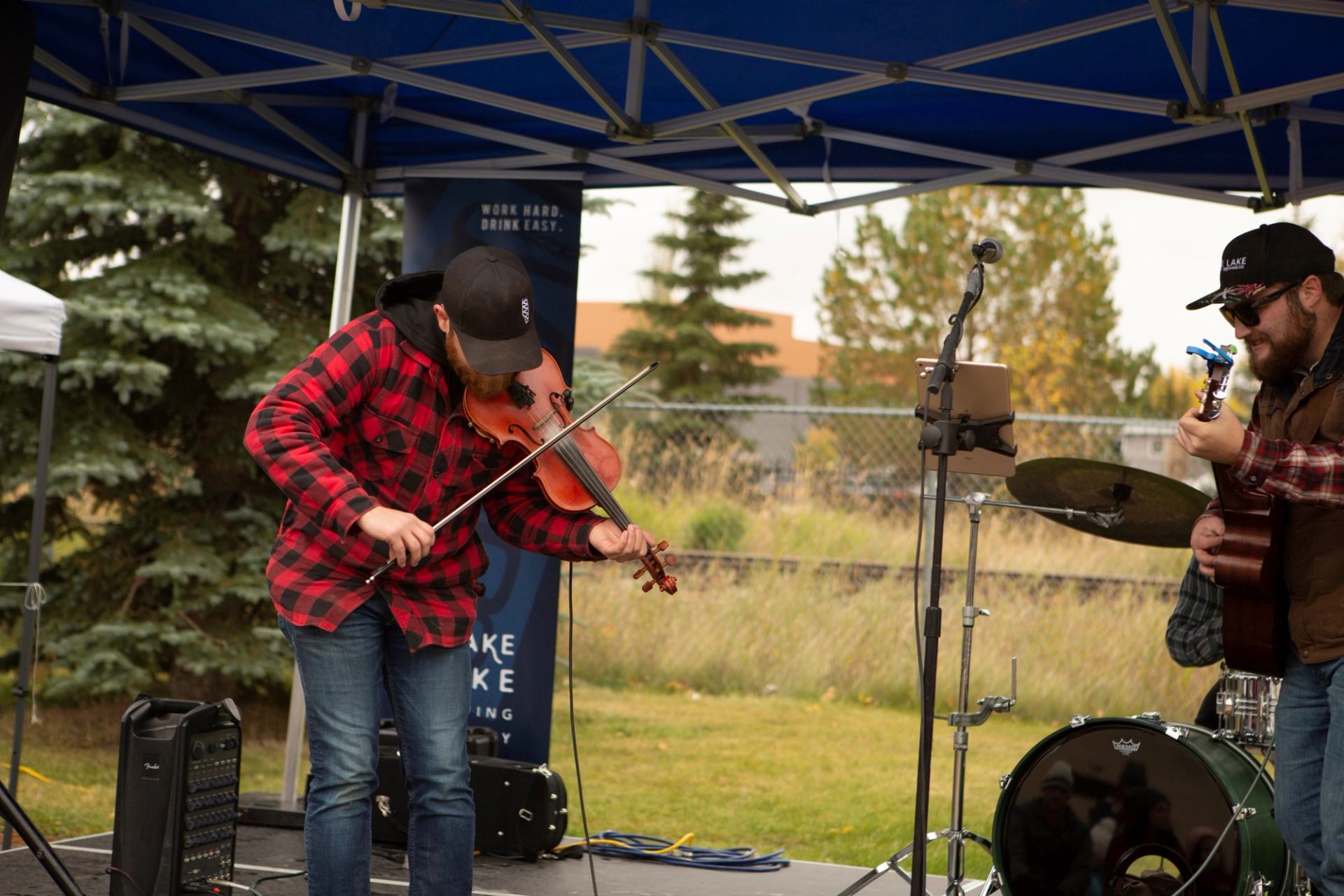 Musicians perform outdoors at Flannel and Feast in flannel and fall attire.