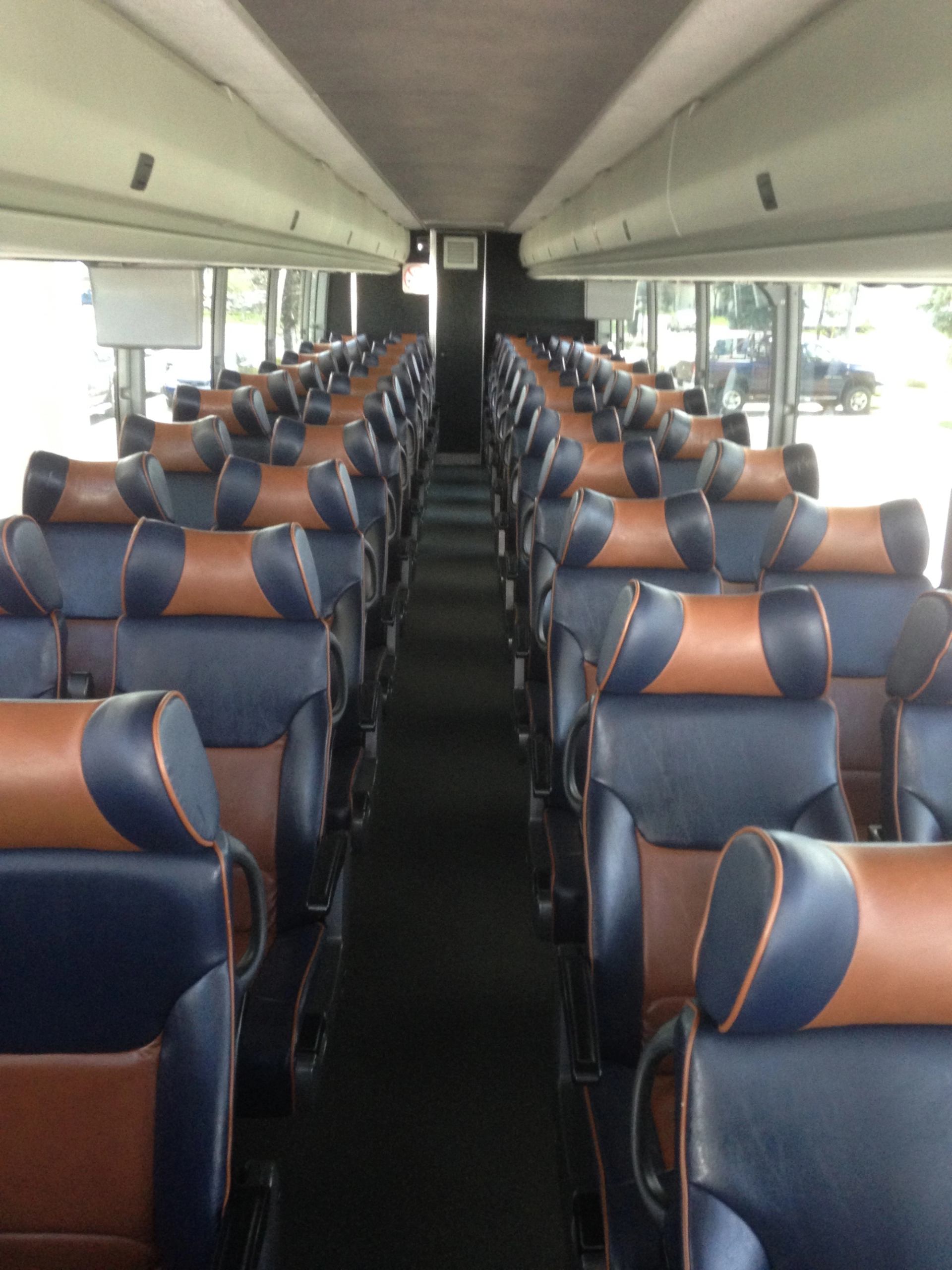 Empty bus interior with blue and brown seats.