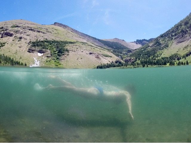 A swimmer dives under water.