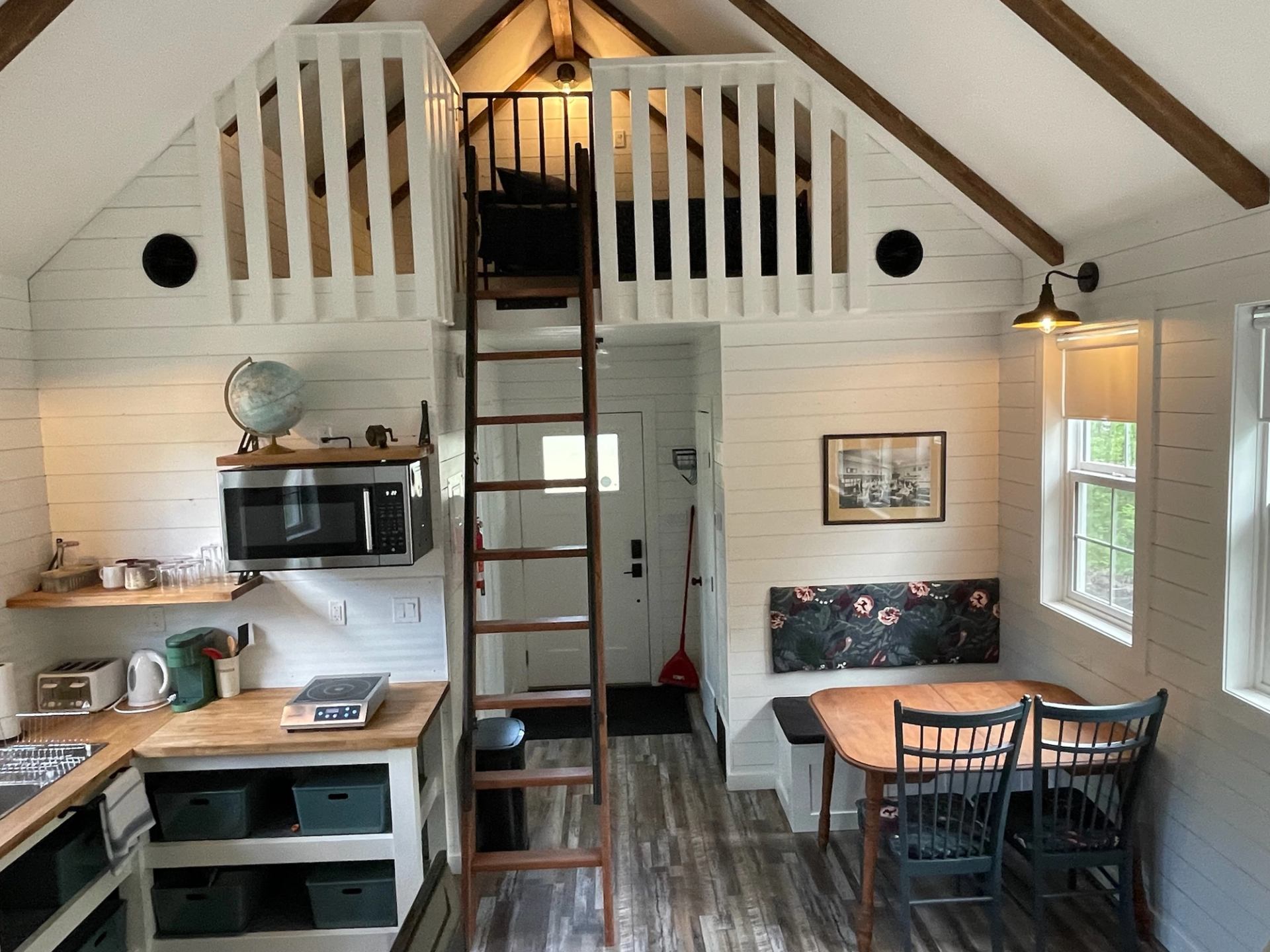 Cozy cabin interior with loft, kitchen, and dining area at Wildly Eweneek Cabins.