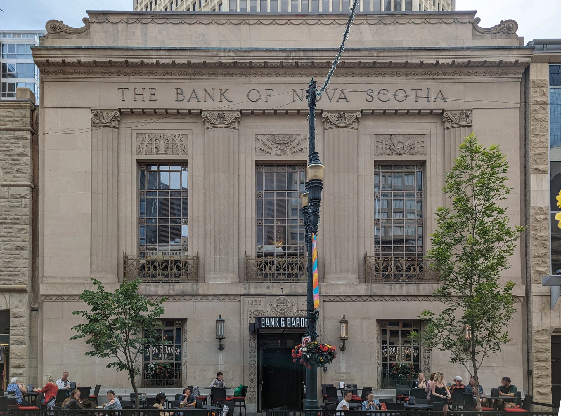 Historic Bank of Nova Scotia building with Bank and Baron pub patio and diners.