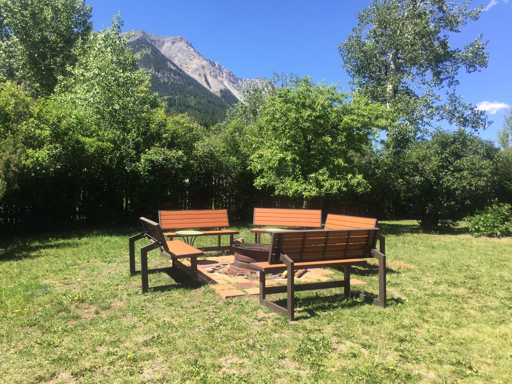Outdoor seating area with benches and fire pit at Larkspur Lodge.